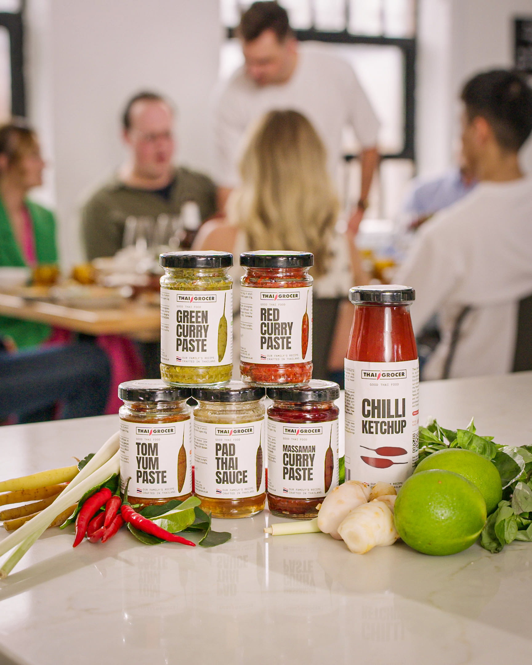 Thai Grocer curry pastes and sauces with guests sharing Thai food